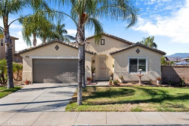 view of front facade with a mountain view, a front yard, and a garage