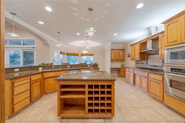 kitchen with decorative light fixtures, a kitchen island with sink, sink, and stainless steel appliances