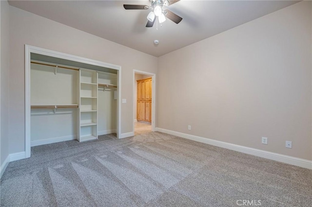 unfurnished bedroom featuring ceiling fan, a closet, and light carpet