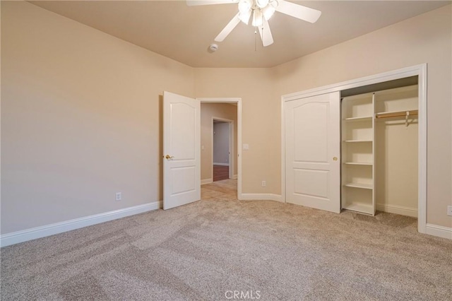 unfurnished bedroom with ceiling fan, a closet, and light carpet