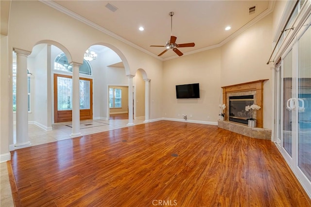 unfurnished living room with ceiling fan, french doors, a premium fireplace, and crown molding