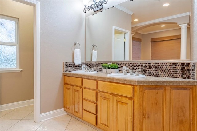 bathroom featuring tile patterned floors, vanity, crown molding, and tasteful backsplash