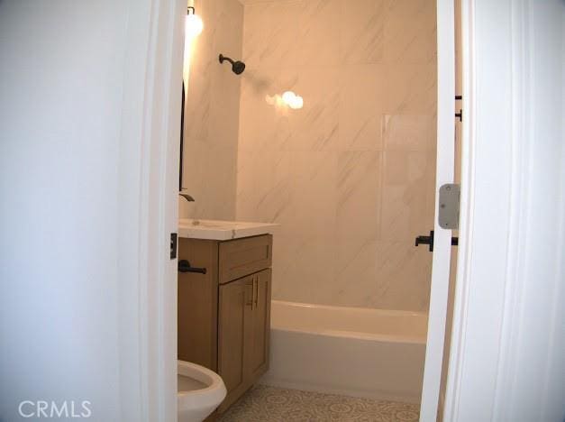 full bathroom featuring toilet, vanity, and tiled shower / bath