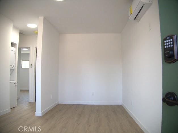 interior space featuring a wall mounted AC and light hardwood / wood-style flooring