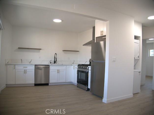 kitchen featuring light hardwood / wood-style floors, sink, stainless steel appliances, and white cabinetry