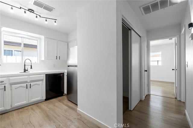 kitchen featuring white cabinetry, light hardwood / wood-style floors, dishwasher, and stainless steel fridge