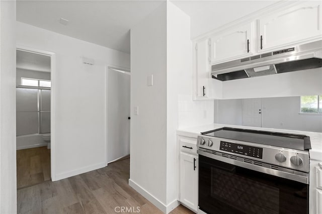 kitchen featuring white cabinetry, light hardwood / wood-style flooring, and stainless steel electric range