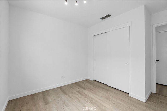 unfurnished bedroom with a closet and light hardwood / wood-style floors