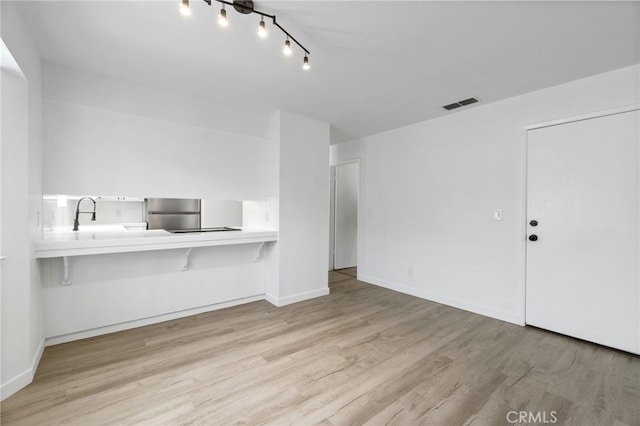 unfurnished living room featuring light hardwood / wood-style floors and sink