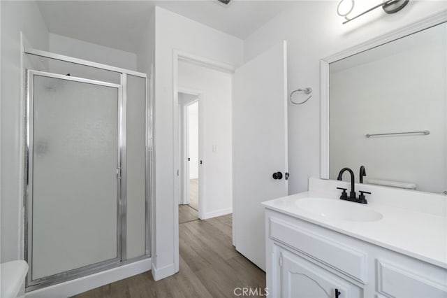 bathroom with a shower with shower door, wood-type flooring, and vanity