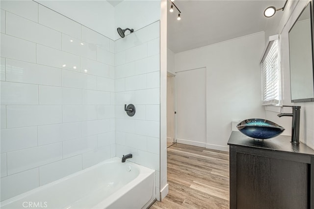 bathroom featuring tiled shower / bath combo, wood-type flooring, and vanity