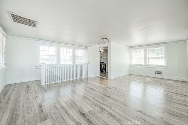 unfurnished living room featuring light hardwood / wood-style floors and crown molding