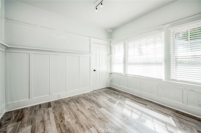 interior space with track lighting and light hardwood / wood-style flooring