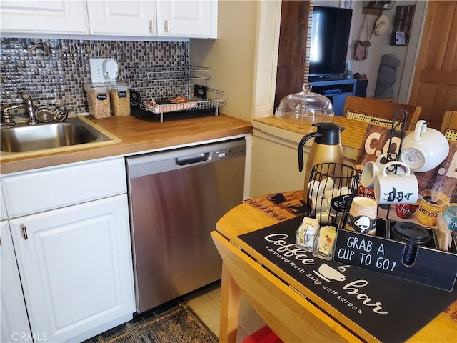 kitchen featuring stainless steel dishwasher, backsplash, sink, and white cabinetry