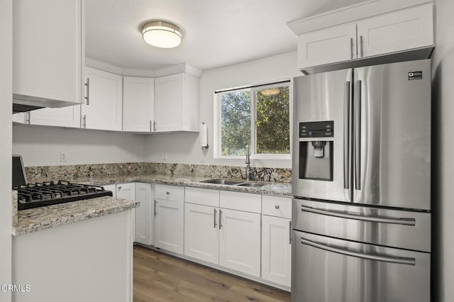 kitchen with white cabinetry, stainless steel fridge, and sink