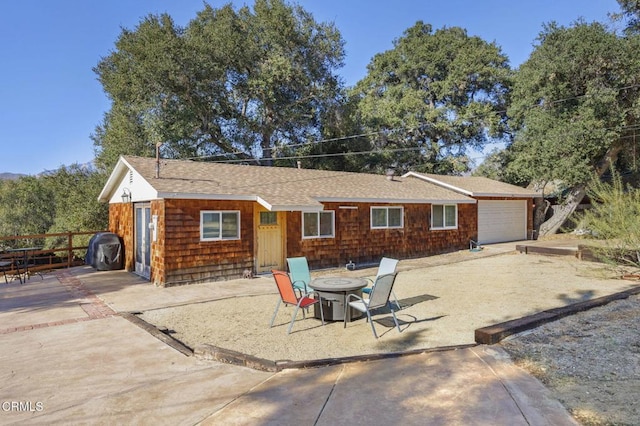 rear view of house with a garage and a patio area