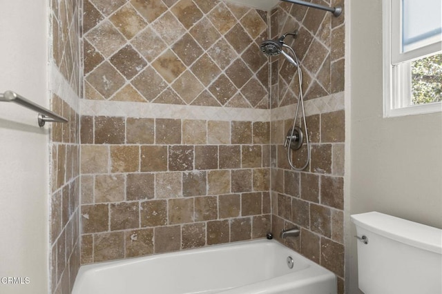 bathroom featuring tiled shower / bath and toilet