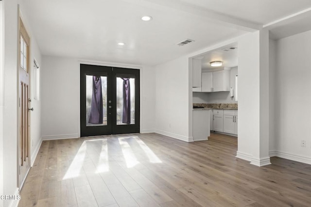 foyer entrance featuring french doors, a healthy amount of sunlight, and light hardwood / wood-style flooring