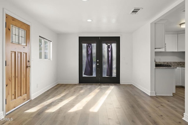 entryway with light hardwood / wood-style floors and french doors