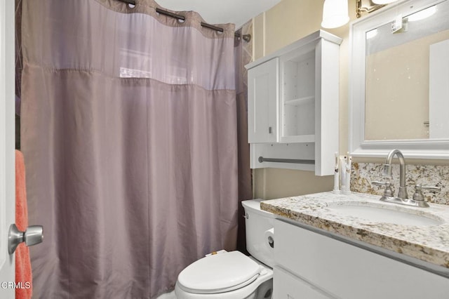 bathroom featuring vanity, toilet, and a shower with shower curtain