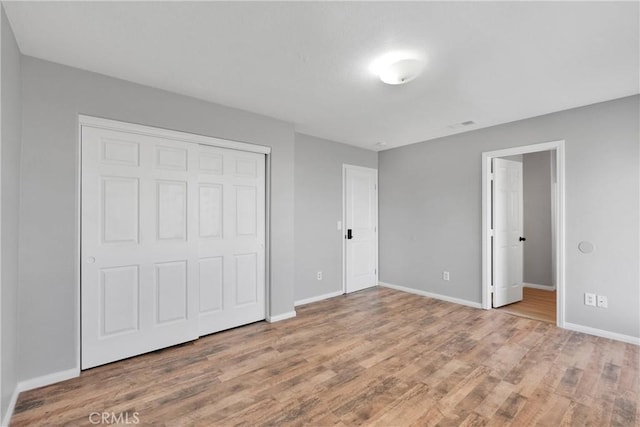 unfurnished bedroom featuring a closet and hardwood / wood-style floors