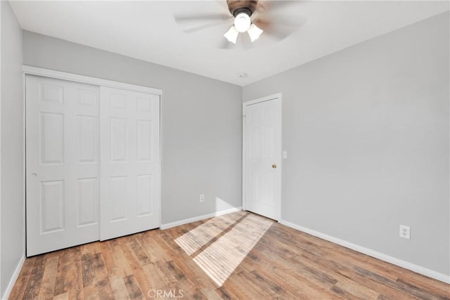 unfurnished bedroom with ceiling fan, a closet, and hardwood / wood-style flooring