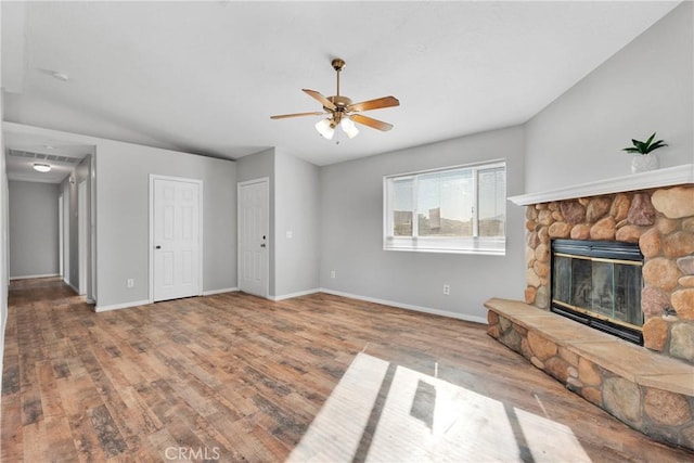 living room featuring ceiling fan, hardwood / wood-style flooring, and a fireplace