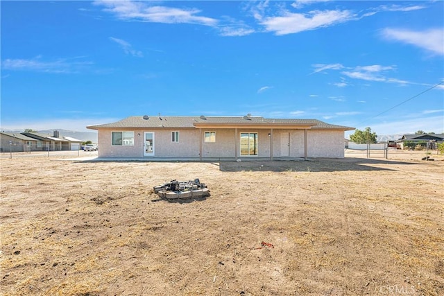 back of property with an outdoor fire pit