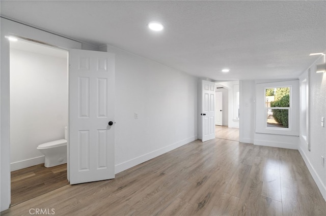 empty room with a textured ceiling and hardwood / wood-style floors