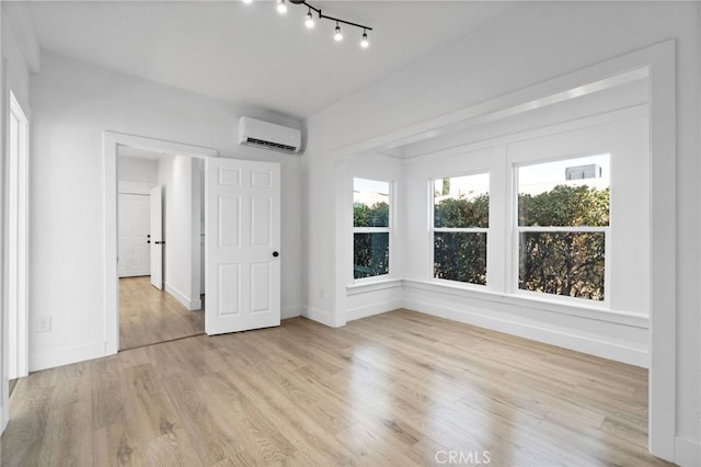 interior space with light hardwood / wood-style floors and a wall mounted air conditioner