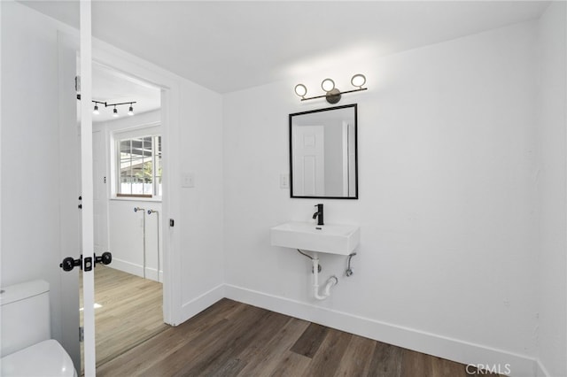 bathroom featuring sink, wood-type flooring, and toilet