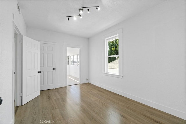 unfurnished bedroom featuring light hardwood / wood-style floors and ensuite bath