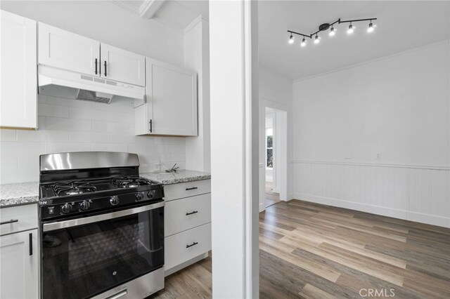 kitchen featuring white cabinets, light wood-type flooring, range with gas stovetop, and light stone counters