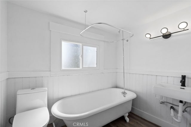 bathroom featuring hardwood / wood-style flooring, sink, toilet, and a bathing tub