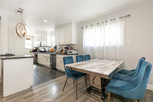 dining room with dark hardwood / wood-style floors, sink, and a notable chandelier