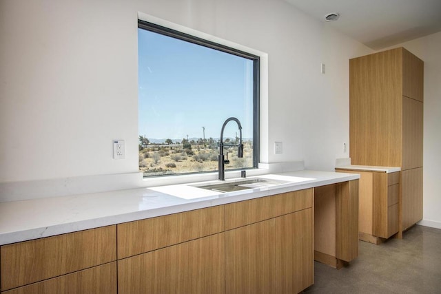 kitchen featuring a wealth of natural light, sink, and concrete flooring