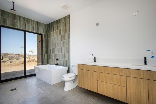 bathroom featuring toilet, concrete flooring, tile walls, and vanity