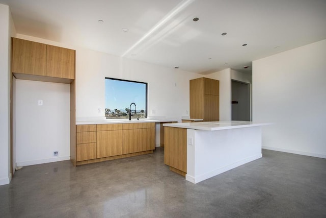 kitchen with concrete flooring, sink, and a center island