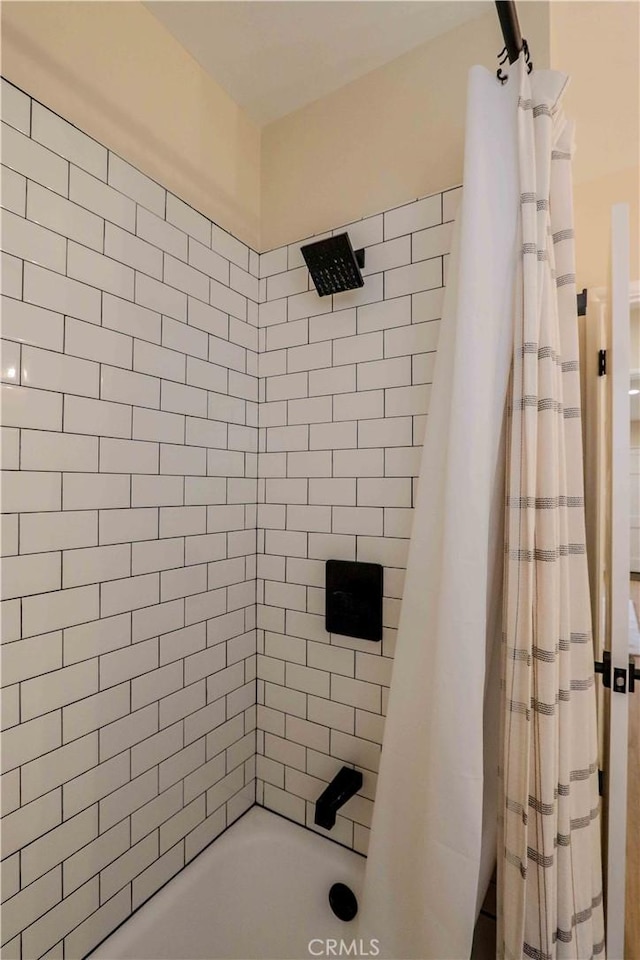 bathroom with shower / bath combo with shower curtain