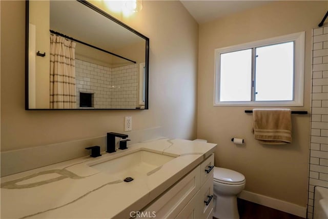 bathroom featuring vanity, toilet, and baseboards