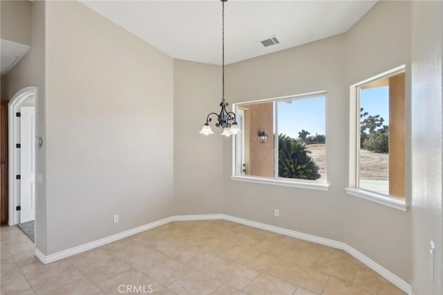 unfurnished dining area with light tile patterned floors and a notable chandelier