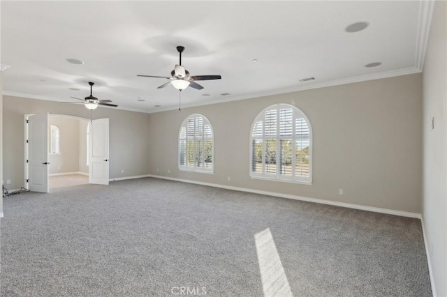 carpeted empty room with ceiling fan and crown molding