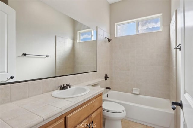 full bathroom featuring toilet, tiled shower / bath, and vanity