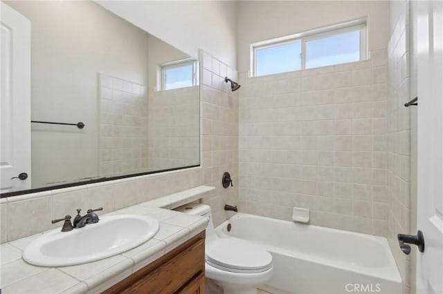 full bathroom with tiled shower / bath combo, vanity, and toilet