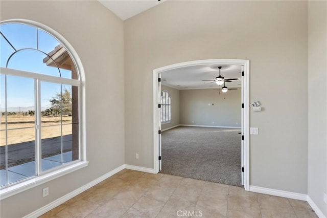 carpeted empty room featuring ceiling fan and plenty of natural light