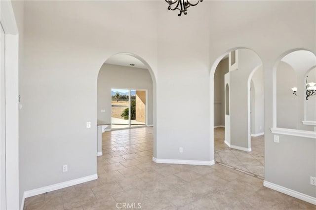 unfurnished room with a chandelier