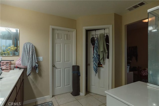 bathroom featuring baseboards, vanity, visible vents, and tile patterned floors