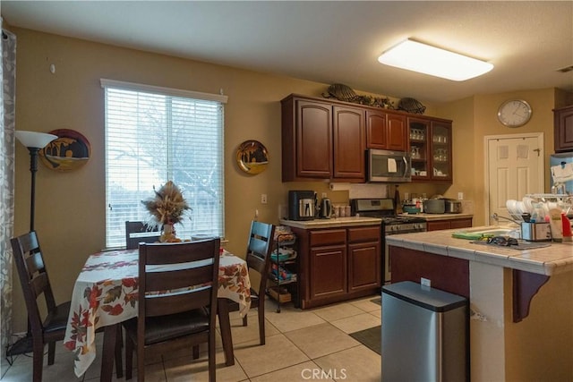 kitchen featuring light tile patterned floors, appliances with stainless steel finishes, and tile counters