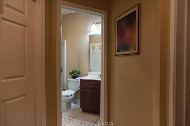 bathroom with toilet, vanity, and tile patterned flooring