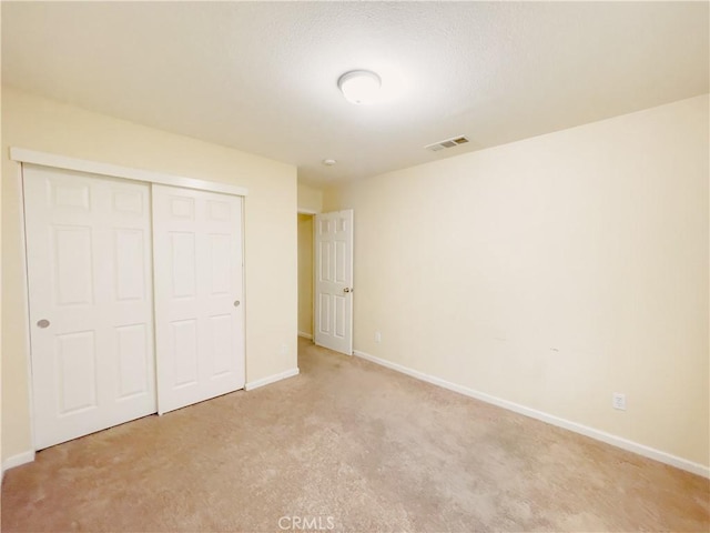 unfurnished bedroom featuring a closet, visible vents, and baseboards